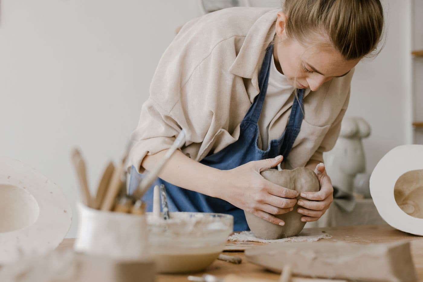 A potter shaping clay for an illustrative pottery workshop post