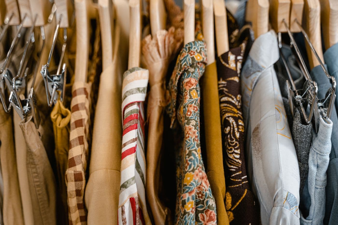 A boutique clothing collection with assorted finished garments displayed on wooden hangers