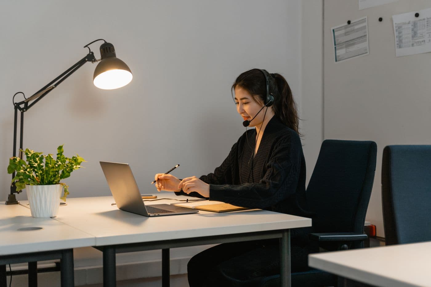 A customer support agent reviewing information on a laptop at her desk